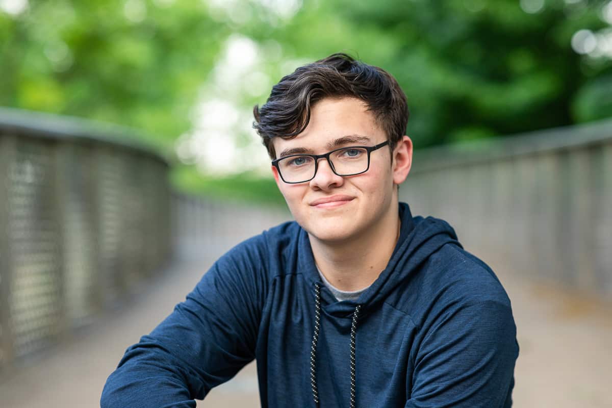 senior boy in navy hoodie in park